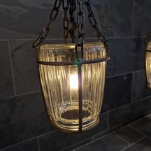 Hängelampe aus Glas für Badgestaltung, moderne Beleuchtung, schlichte Form, dekoratives Leuchtelement in Badezimmer.