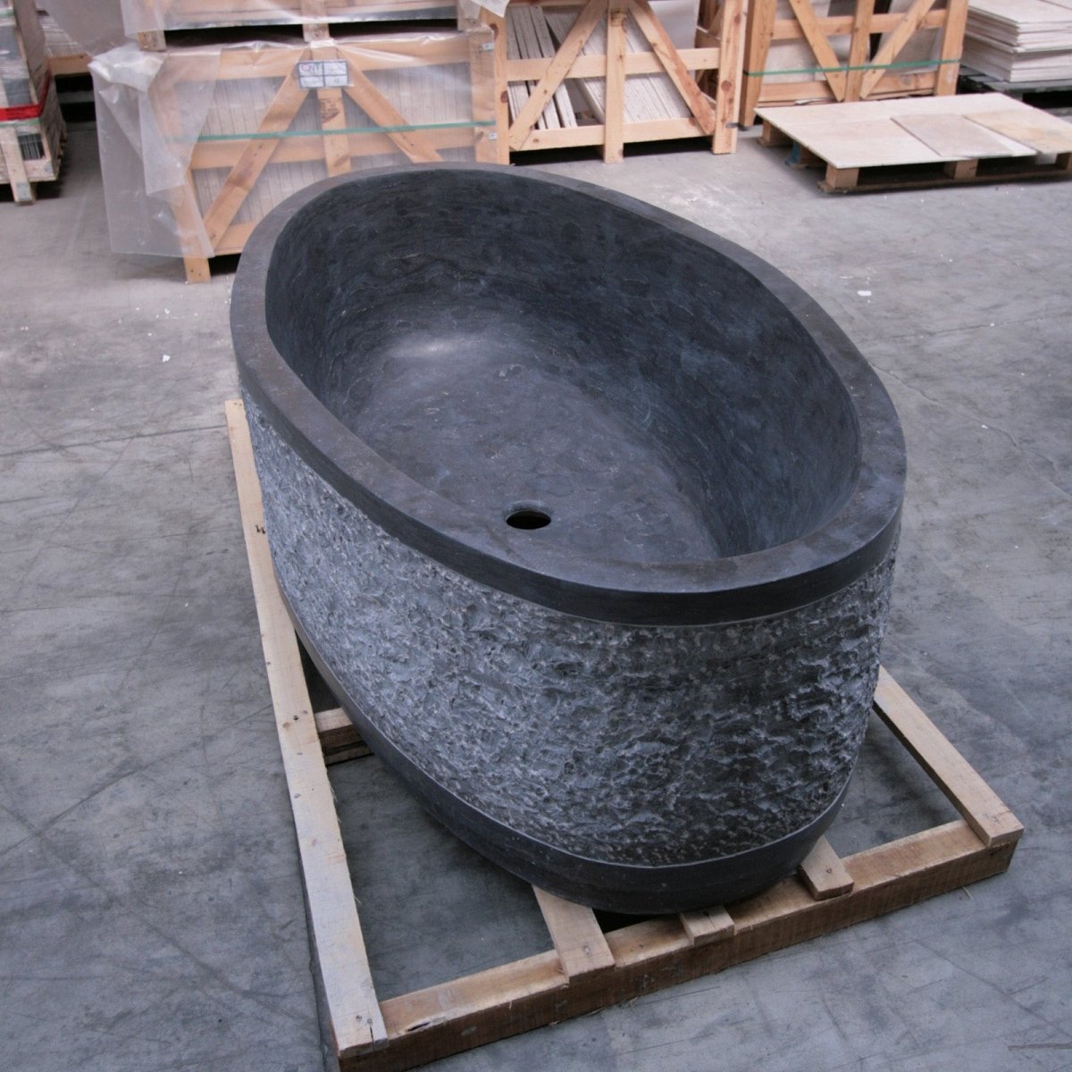 Freistehende Badewanne von Atlantis aus Blaustein, Teil der Badgestaltung, mit glatter Oberfläche und eleganter Form.