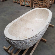 Freistehende Badewanne aus beige Marmor, Teil der WAVE Badgestaltung, zeigt elegante, runde Form und glatte Oberfläche.